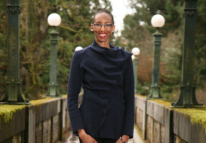 Dr. McKinney stands on a bridge surrounded by trees. 