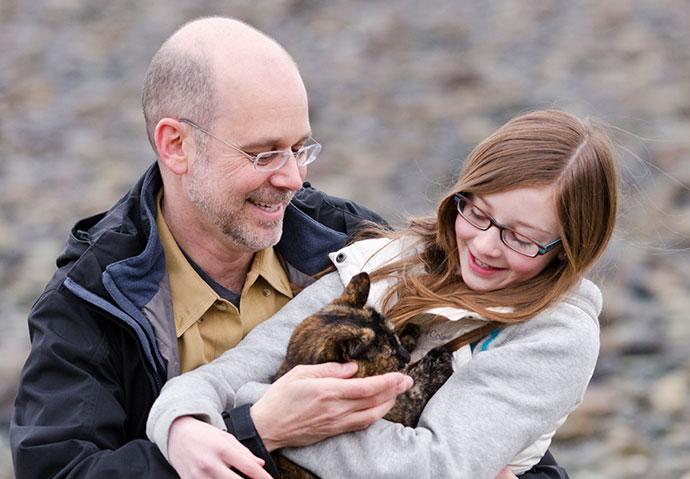 Mike and his daughter Mallory cuddle their dog. 